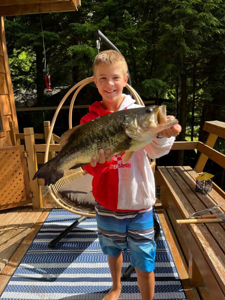 Kaden is the 11 year old son of boat club members Caitlin and Kristopher Lee, and grandson of Carol Murray.  For over a year he saved his money and was able to purchase an 10 foot fishing kayak.  He spent a week with Carol in July and set out one early morning in this kayak.  Soon Carol heard him yelling and she rushed down to the dock to see him holding this 22", 8 pound large mouth bass with a 15 1/2" girth.  According to the DEC data, the fish is estimated to be the same age as Kaden.  He said it was a struggle to land in his kayak and then hold it while paddling back to shore.   With fierce determination, he made it.  While Carol was thinking "fish fry tonight", his parents and everyone else encouraged him to freeze it for future mounting.  AND - in true fisherman style - when Carol asked him where he caught it, Kaden's response was " in the water ".